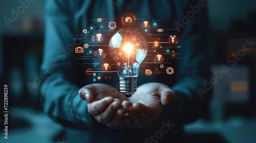 Businessman holding glowing lightbulb with learning icons for study knowledge to creative thinking idea and problem solving solution concept photo