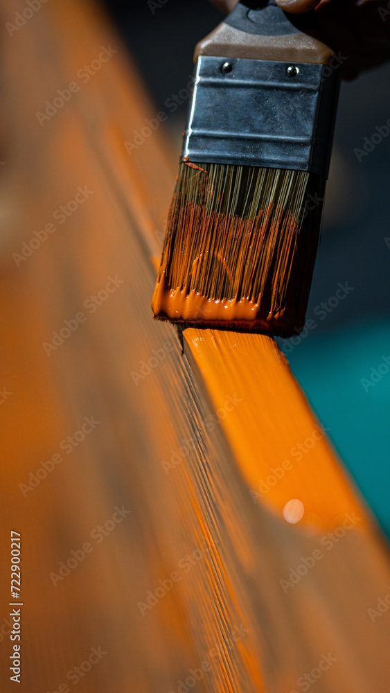 painting a wooden bench with a brush - protecting the coating