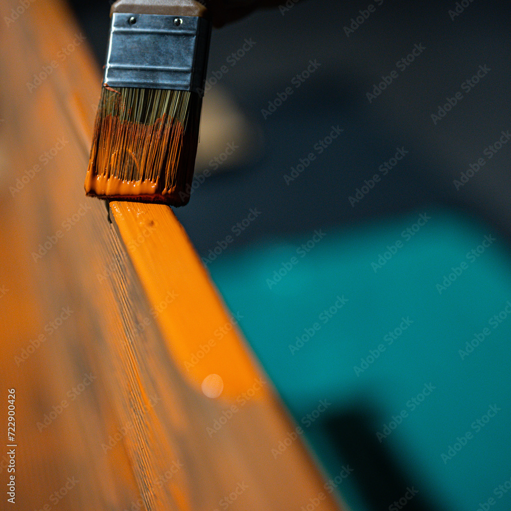 painting a wooden bench with a brush - protecting the coating