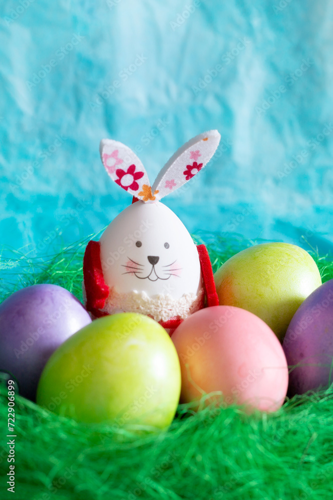 Colorful Easter eggs, green nest and bunny rabbit