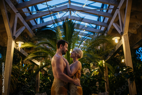 Beautiful couple standing in hotel greenhouse, looking at each another, enjoying romantic wellness weekend in spa. Concept of Valentine's Day. © Halfpoint