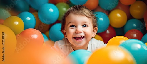 Happy laughing boy 1 2 years old having fun in ball pit on birthday party in kids amusement park and indoor play center in playground ball pool Activity toys for little kid. Creative Banner photo