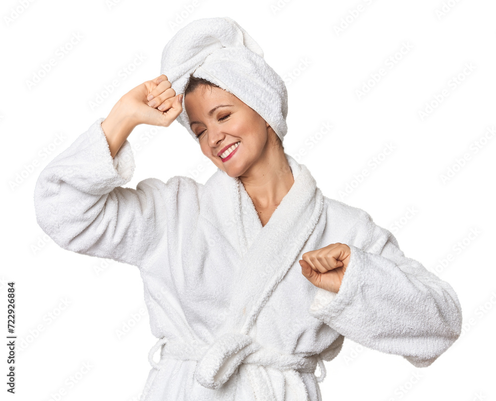 Caucasian woman in bathrobe and towel celebrating a special day, jumps and raise arms with energy. Caucasian woman in bathrobe and towel celebrating a special day, jumps and raise arms with energy.