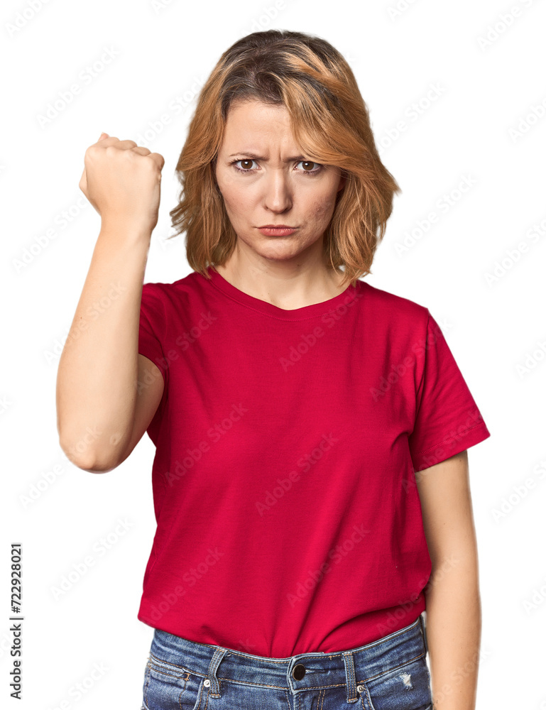 Blonde middle-aged Caucasian woman in studio showing fist to camera, aggressive facial expression. Blonde middle-aged Caucasian woman in studio showing fist to camera, aggressive facial expression.