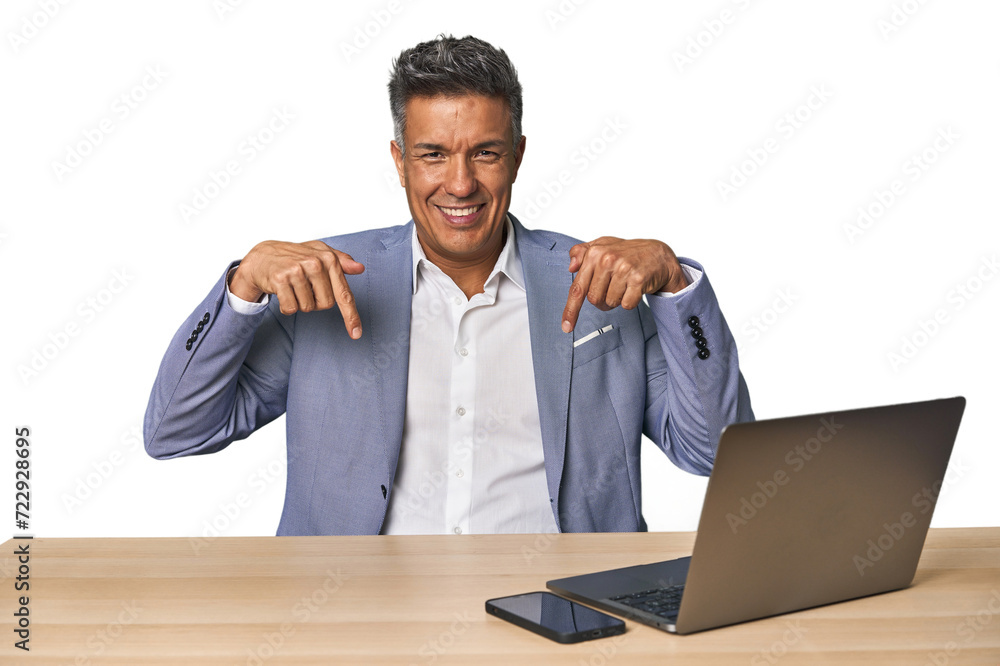 Elegant businessman at desk with laptop points down with fingers, positive feeling. Elegant businessman at desk with laptop points down with fingers, positive feeling.