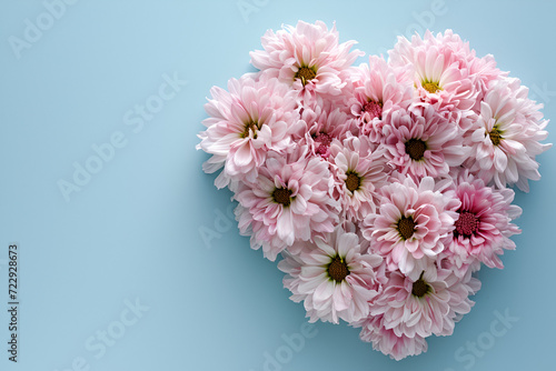 Heart shaped pink flower bouquet on a blue background  in the style of unique framing and composition.