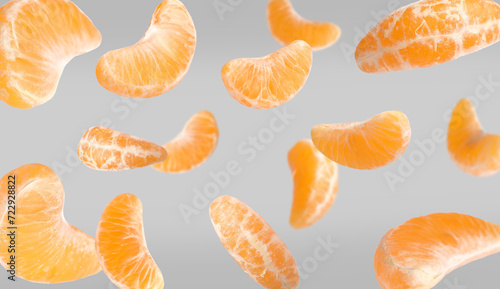 Pieces of fresh ripe tangerine falling on grey background, banner design