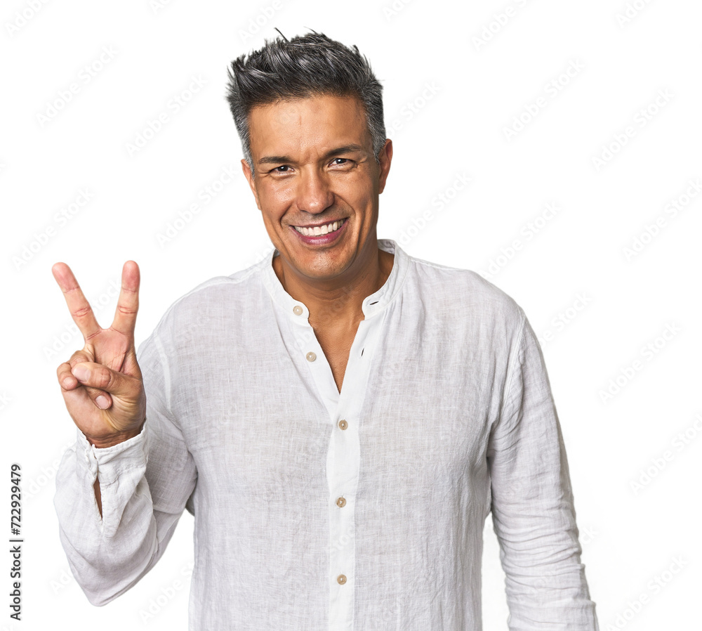Middle-aged Latino man showing victory sign and smiling broadly. Middle-aged Latino man showing victory sign and smiling broadly.