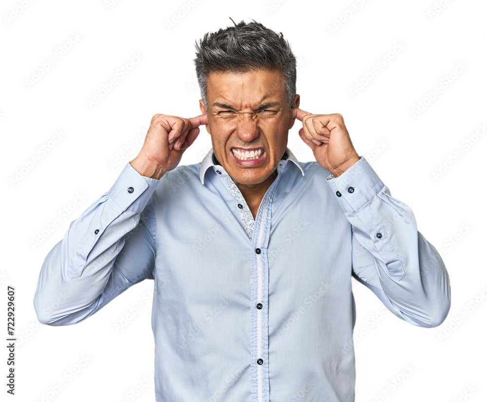 Middle-aged Latino man covering ears with fingers, stressed and desperate by a loudly ambient. Middle-aged Latino man covering ears with fingers, stressed and desperate by a loudly ambient.