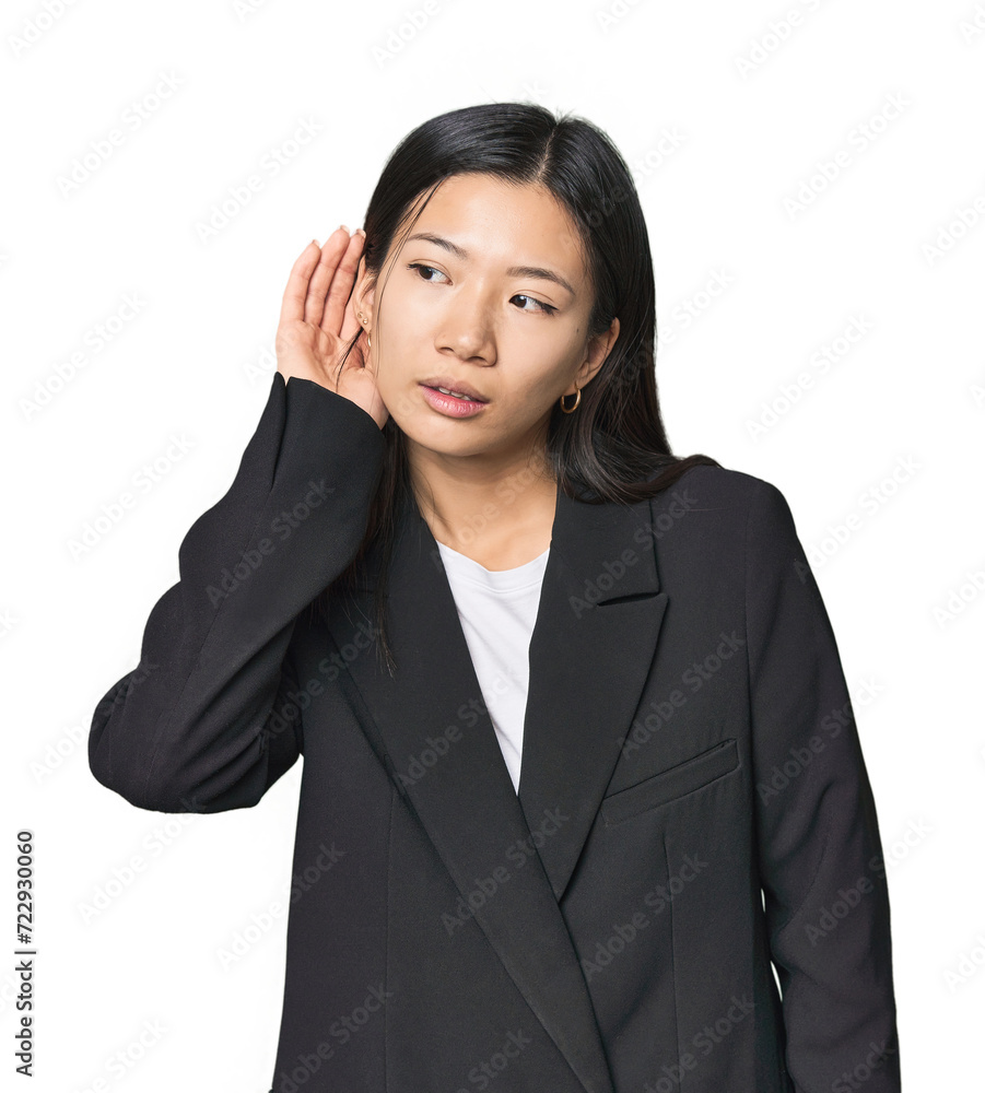 Young Chinese woman in business suit trying to listening a gossip. Young Chinese woman in business suit trying to listening a gossip.
