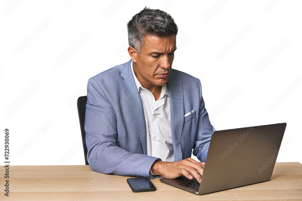 Middle-aged Hispanic man working on laptop in business suit Middle-aged Hispanic man working on laptop in business suit