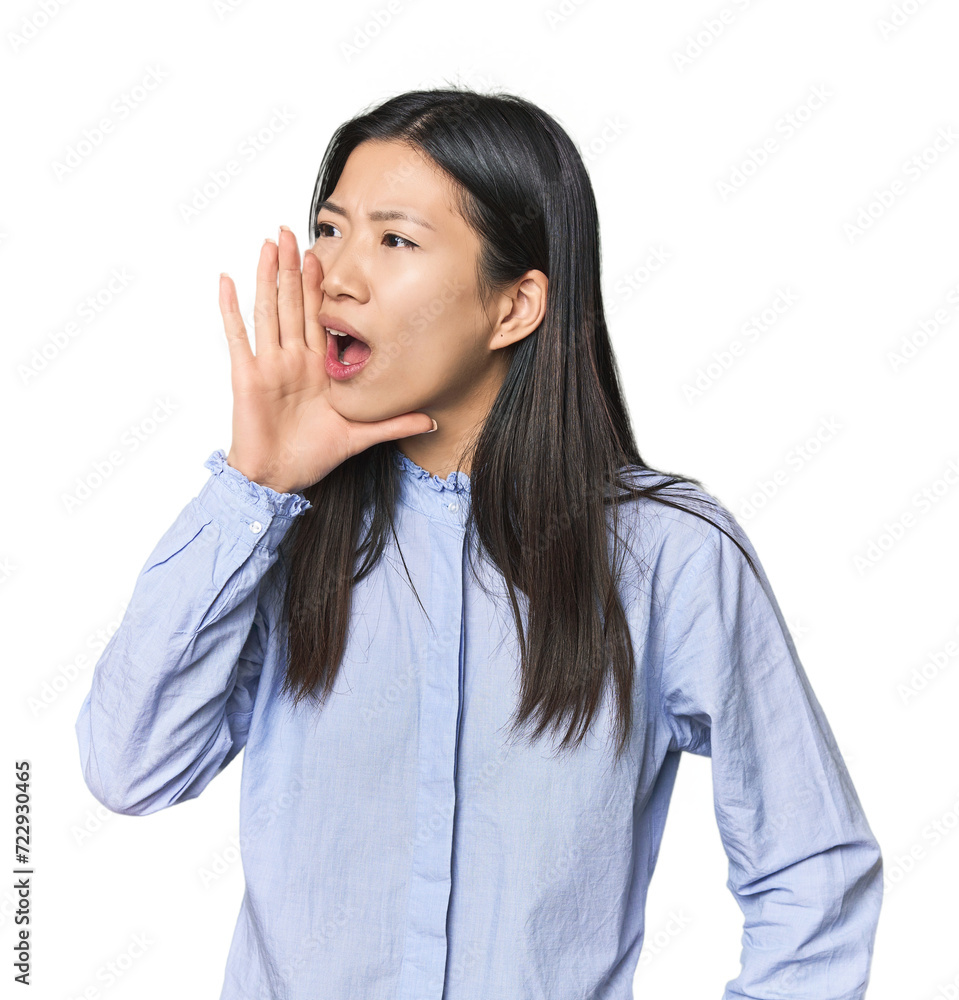 Young Chinese woman in blue shirt shouting and holding palm near opened mouth. Young Chinese woman in blue shirt shouting and holding palm near opened mouth.
