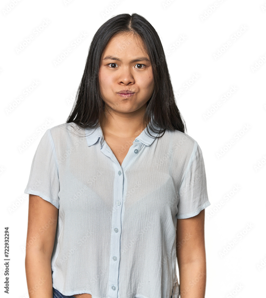 Young chinese woman isolated blows cheeks, has tired expression. Facial expression concept. Young chinese woman isolated blows cheeks, has tired expression. Facial expression concept.