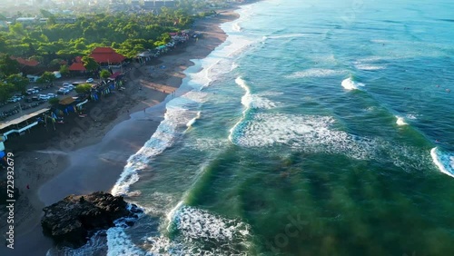 Big Sacred Rock on Canggu beach in Bali with beach, surfers and village in the morning sun photo
