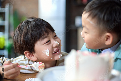 Two brothers eating birthday cake together photo