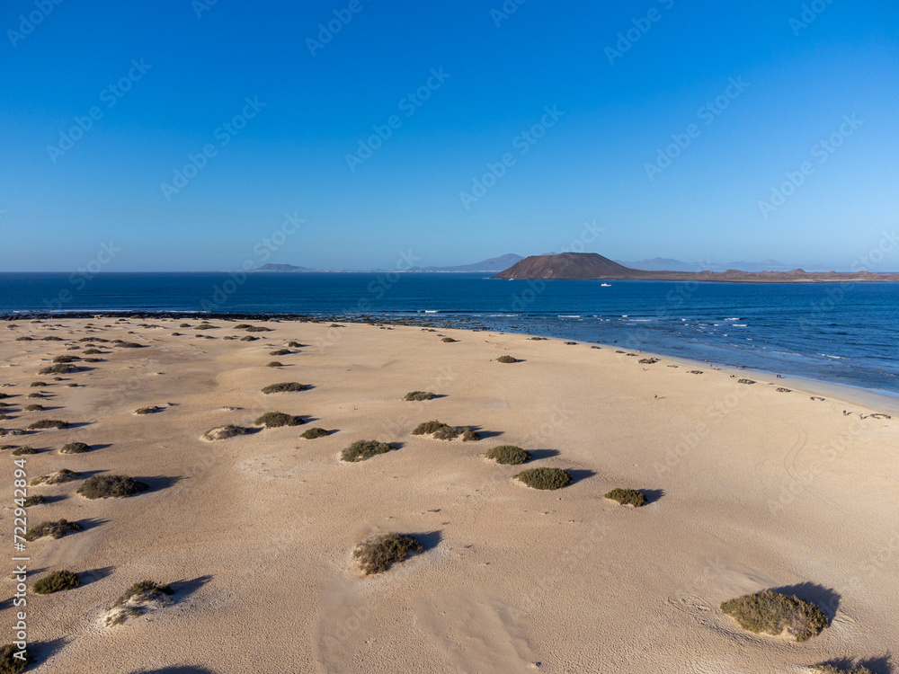 Aerial view Corralejo dunes, white sandy beach, blue water, Lobos and Lanzarote islands, Fuerteventura, Canary islands, Spain Aerial view Corralejo dunes, white sandy beach, blue water, Lobos and Lanzarote islands, Fuerteventura, Canary islands, Spain