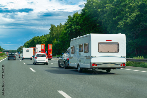 Caravan driving on asphalt road between Germany and Austria.