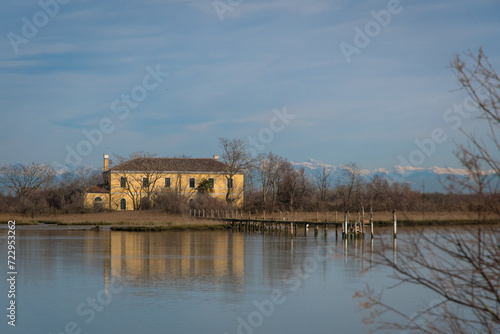 Una villa storica si riflette nelle acque di un canale lungo il Sentiero dei Casoni a Caorle