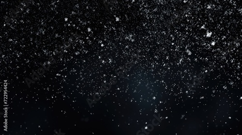 Snow falling down into the air on a black background. Perfect for winter-themed designs and holiday projects © Fotograf