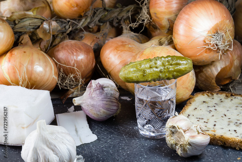 glass with alcohol and cucumber, lard, garlic, onion