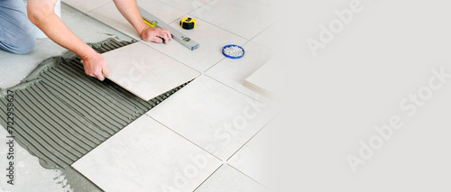 Fotografie A man lays tiles on the floor, a place for text