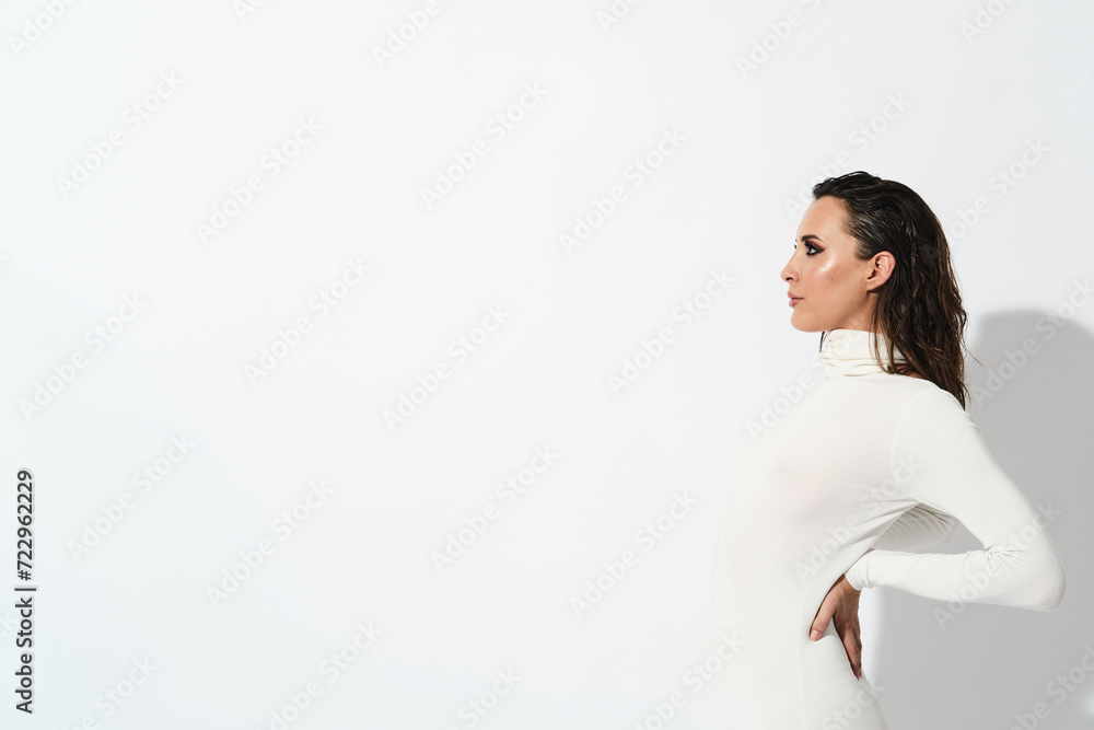 Landscape portrait of a very beautiful woman wearing a very fit white dress and red heels on a white background with free space at the left Landscape portrait of a very beautiful woman wearing a very fit white dress and red heels on a white background with free space at the left