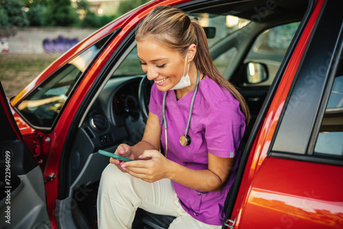Konstfotografi Waiting in car, nurse scrolls through social media on phone.