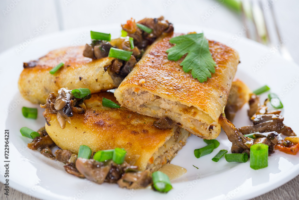 fried thin pancakes stuffed with meat and mushrooms. fried thin pancakes stuffed with meat and mushrooms.