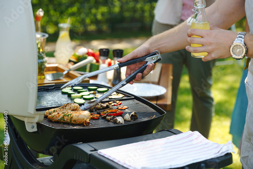 Meat and vegetables grilling on outdoor grill. Outdoor grill or BBQ party in the garden. photo