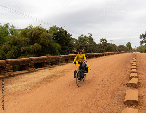 Valokuva Traveler nomadic woman on her bicycle loaded with bags passing