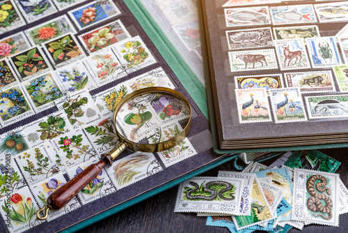 Ukraine, Kiyiv - January 12, 2023.Postage stamps.Collection of stamps and magnifying glass.A collection of world stamps in a pile.Postage stamps from different countries and times