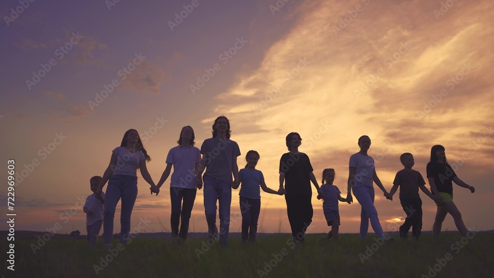 large friendly community family silhouette walk in the park. friendly family holding hands walking in nature in the park. happy family kid concept. silhouette large group people dream holding hands large friendly community family silhouette walk in the park. friendly family holding hands walking in nature in the park. happy family kid concept. silhouette large group people dream holding hands