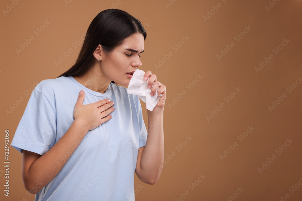Woman with tissue coughing on brown background, space for text. Cold symptoms Woman with tissue coughing on brown background, space for text. Cold symptoms