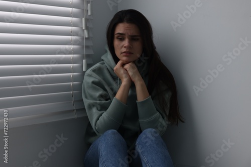 Sadness. Unhappy woman near window at home