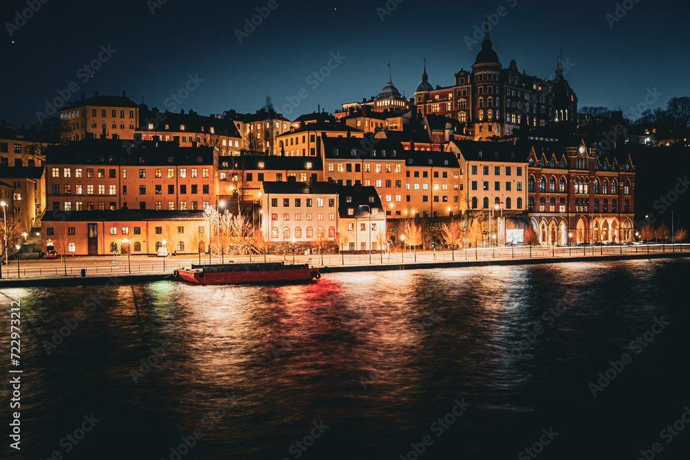 a lit up city at night in front of a river