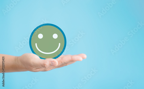 Employee hand holding happy smile face, positive thinking, result mental health assessment, good feedback rating and positive customer review, satisfaction survey, world mental health day concept