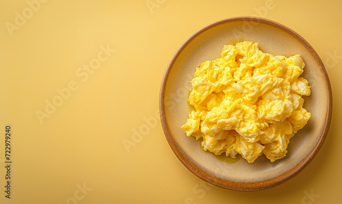 tasty scrambled egg on a plate on a clear background with copy space for text, top view