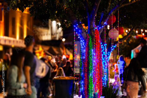 Tree decorated with garlands at multicultural festival event at night photo