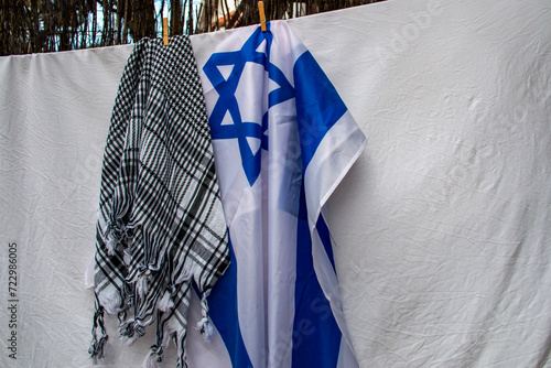 Israel flag and Palestinian scarf together lying on a rope to dry after washing or lying on a surface