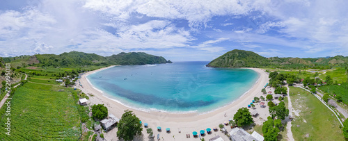 Panoramic aerial view of Mawun beach near Kuta Lombok, Indonesia, on a sunny day with white sand and turquoise waters, mountains in the distance and countryside. Quiet beachclubs photo