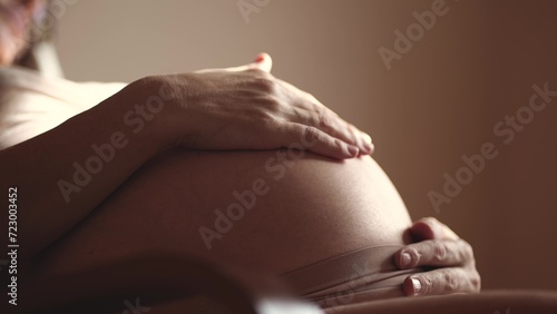 pregnant woman. health pregnancy motherhood procreation concept. close-up belly of a pregnant woman. woman waiting for a newborn baby sunlight. pregnant woman holding her belly indoors photo