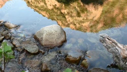 Reflection of mountain on the surface of a river flowing through a canyon