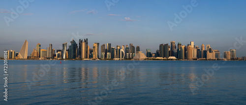 Panorama photo for a view of the Doha Corniche and the towers, one of the most beautiful places in Qatar with blue sky  © Salim