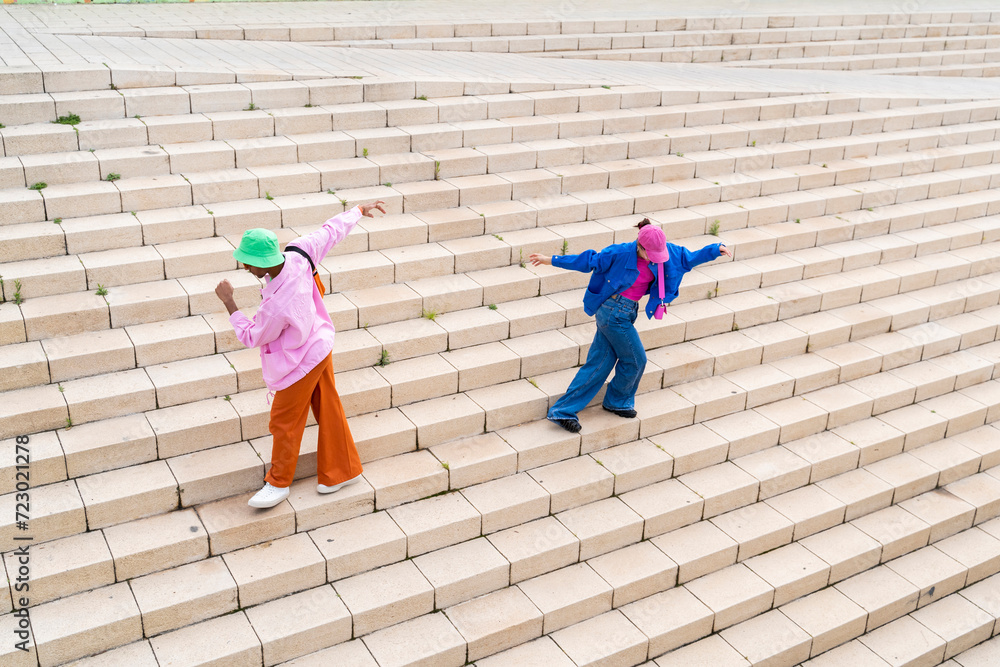 © VISTA by Westend61 - Carefree multiracial couple dancing on staircase