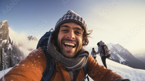 Hiker taking a selfie on the top of a mountain in winter