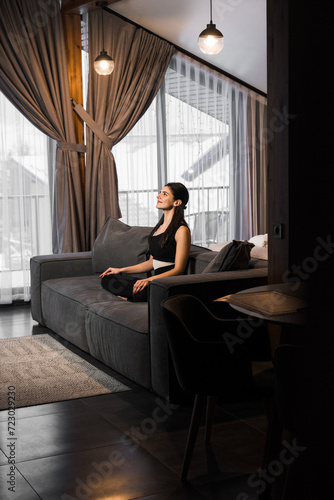 Athletic woman doing meditation at home in a cozy apartment. Yoga and meditation concept. Home fitness