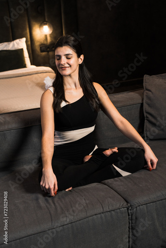 Athletic woman doing meditation at home in a cozy apartment. Yoga and meditation concept. Home fitness