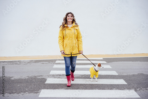 Smiling woman crossing road with Jack Russell Terrier dog photo
