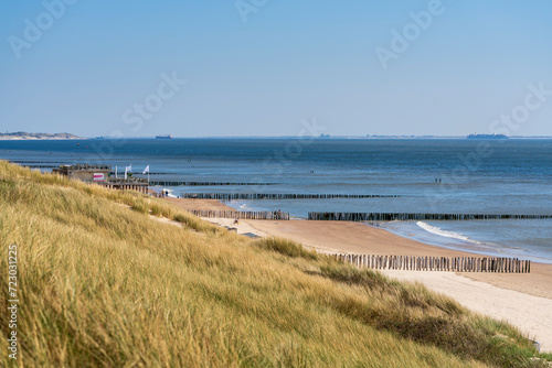 Overlooking from the dunes, the beach and sea by Westkapella in Zeeland unfold under the radiant sunlight of a serene winter day, offering a breathtaking vista of coastal tranquility and nature