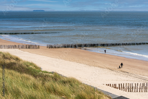 Looking downwards from the sanddunes  the beach and sea by Westkapella in Zeeland unfold under the radiant sunlight of a serene winter day  offering a breathtaking vista of coastal tranquility